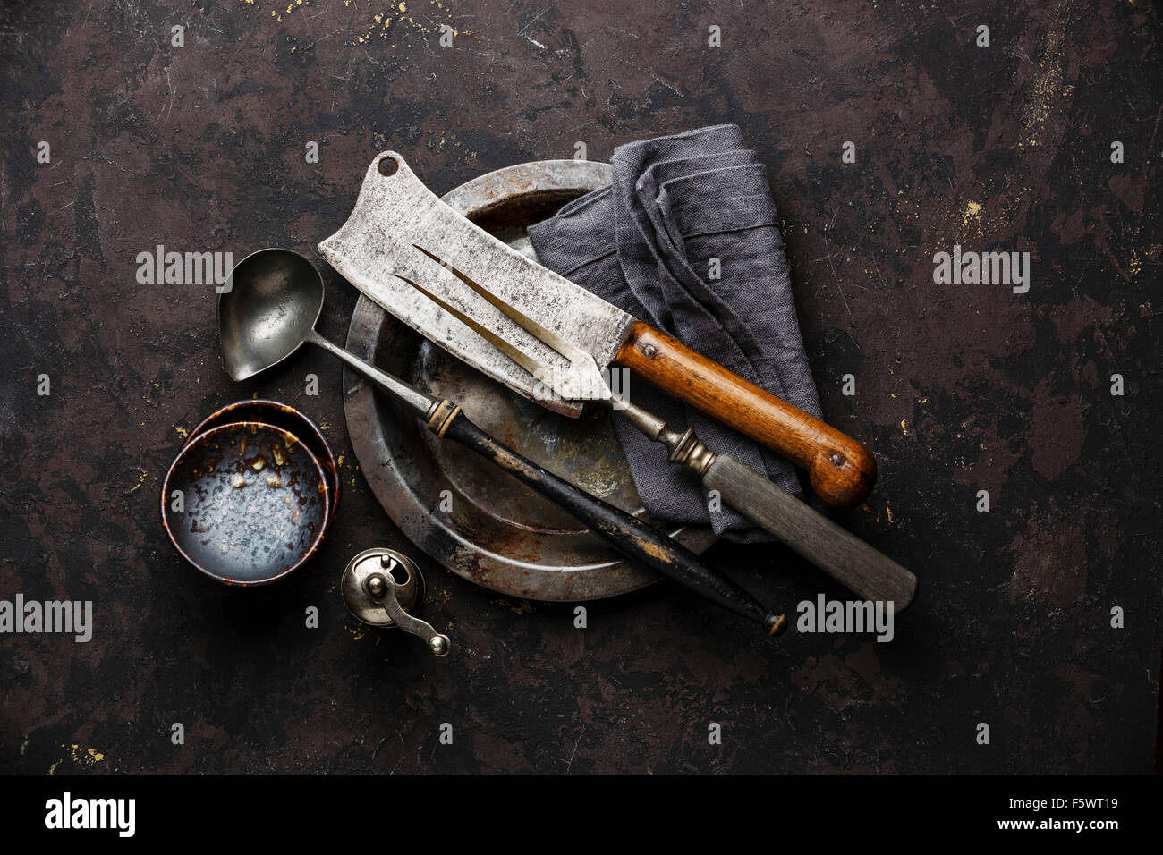 Vintage Geschirr Fleischgabel und Metzger Beil auf schwarzem Hintergrund Stockfoto