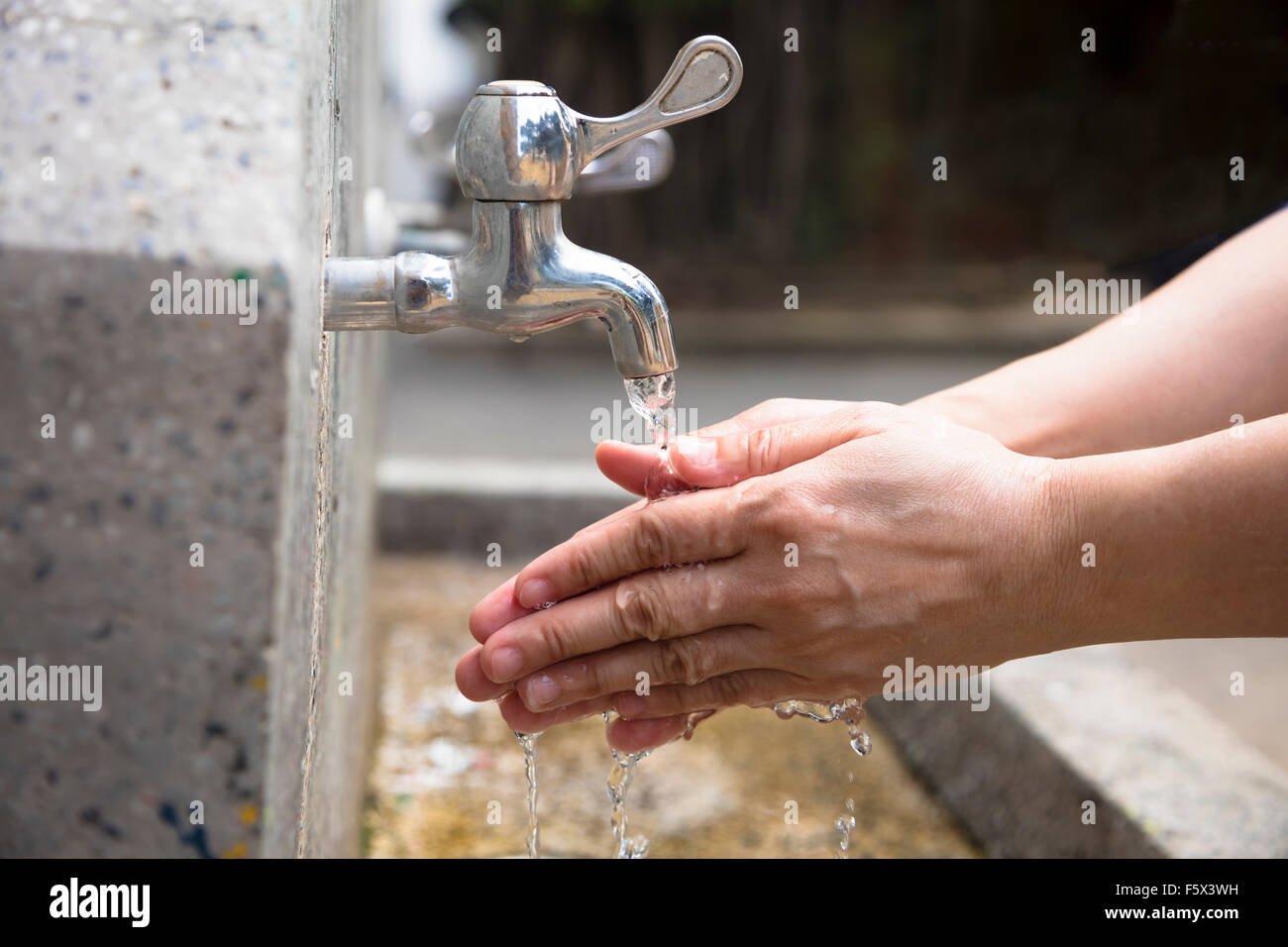 Waschen der Hände unter fließendem Wasser im freien Stockfoto