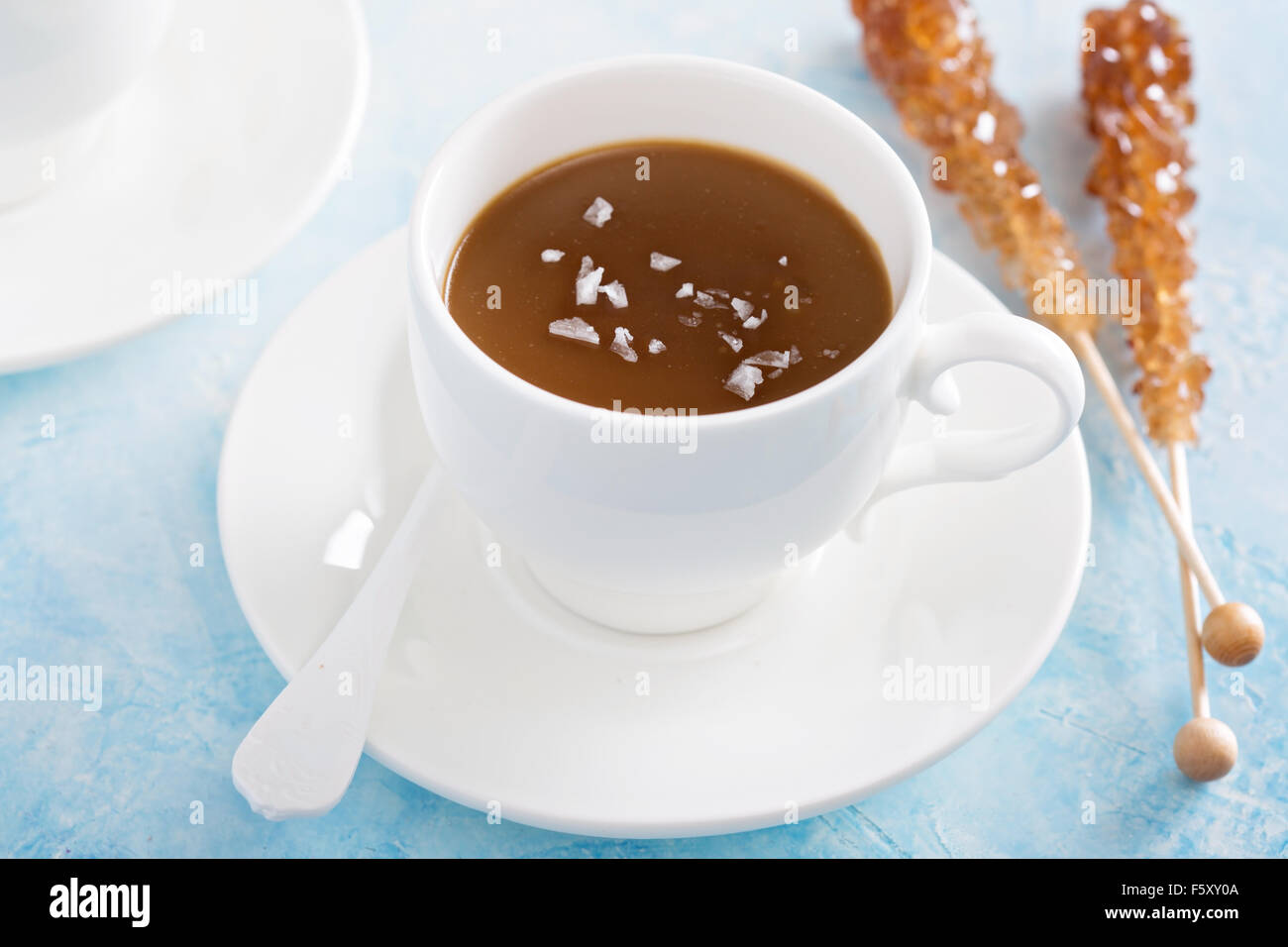Karamell-Pudding in weißen Schalen mit Flocken Salz Stockfoto