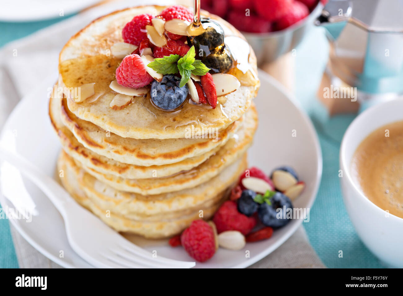 Flauschige Haferflocken Pfannkuchen Stapel mit frischen Beeren, Kaffee und Sirup Stockfoto