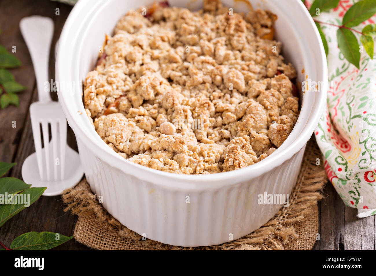 Pfirsich-Crumble in eine weiße Auflaufform Stockfoto