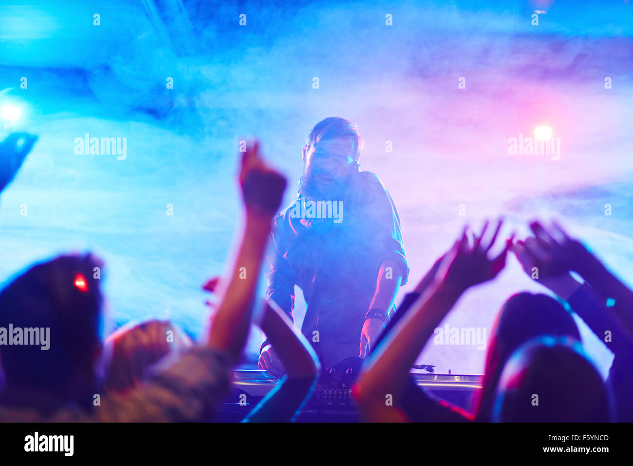 Energetische Deejay und tanzende Menge genießen disco im Nachtclub Stockfoto