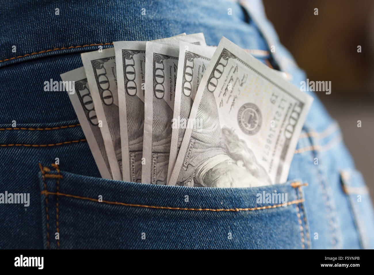 Pack-Dollar-Banknoten in Frau Jeans-Tasche Stockfoto