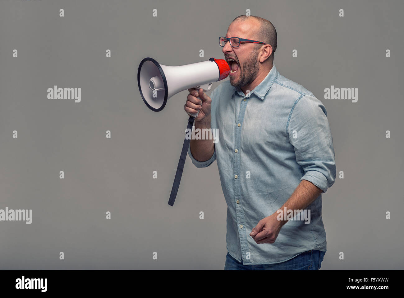 Mann spricht über ein Megaphon, da er eine öffentliche Adresse macht, beteiligt sich an einem Protest oder eine Rallye oder Promotion, über Gr organisiert Stockfoto