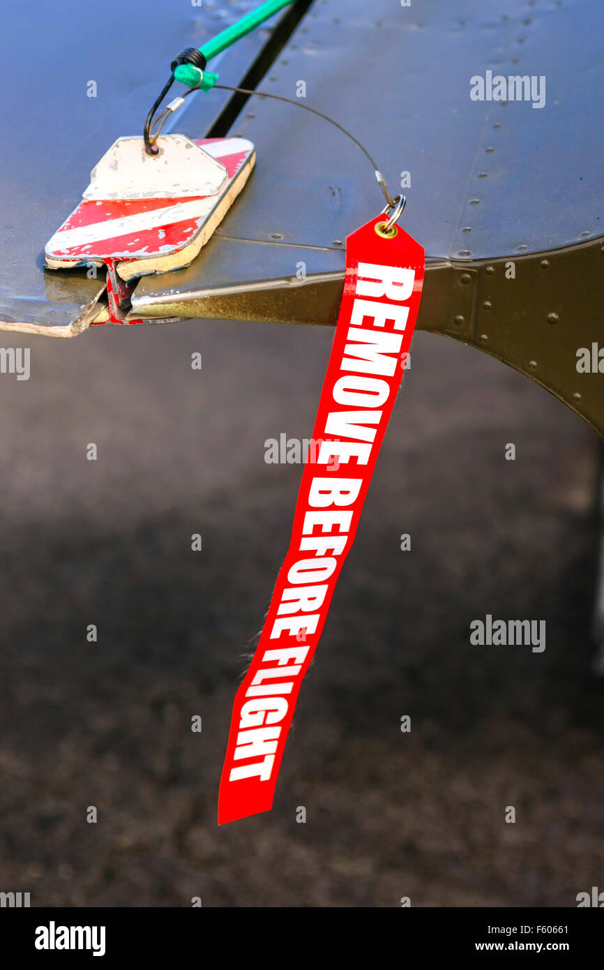 Entfernen Sie vor dem Flug rot und weißen Tag angebracht, ein Aufzug Unterlegkeil auf einer Ebene Stockfoto