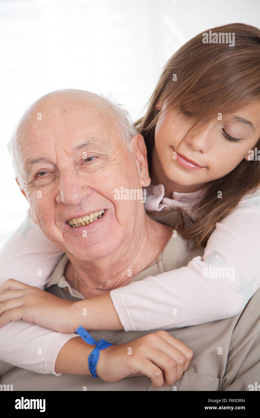 Enkelin gab eine Umarmung zu ihrem Großvater Stockfoto