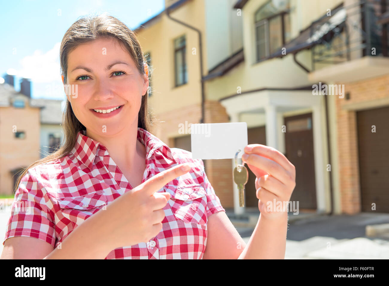 30 Jahre alt Mädchen lächelt und Punkte auf den Schlüssel zur Wohnung Stockfoto