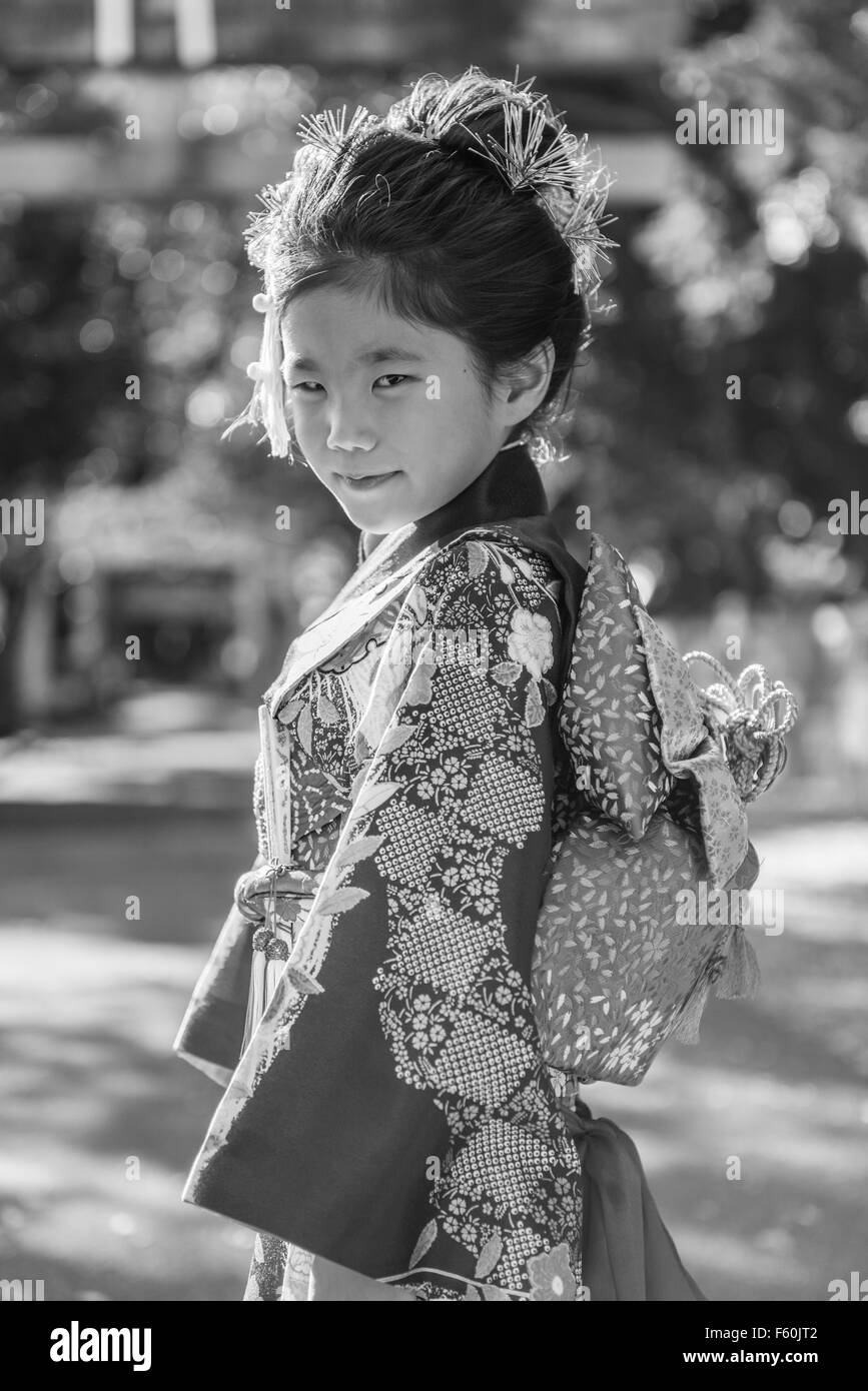 Eine junge Japanerin in einem Kimono im Freien in einem Schrein. Stockfoto