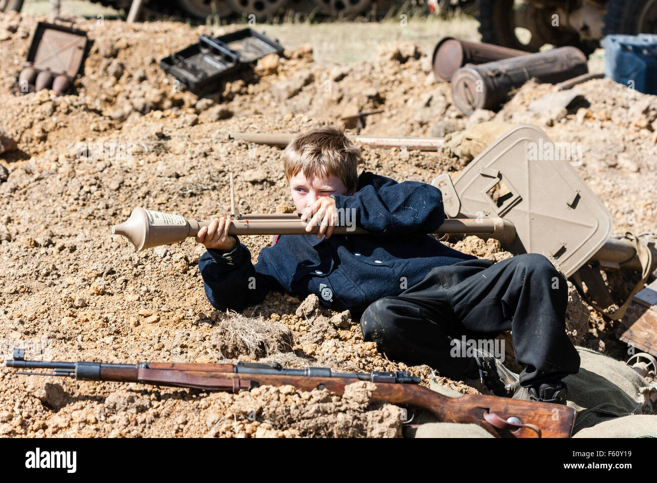 WW2re-enactment, Deutsch Hitler Jugend, Kind 10-14 Jahre alt, Festlegung auf dem Boden inmitten von Krieg Ablagerungen Ziel Anti-tank Weapon, Panzerfaust. Stockfoto