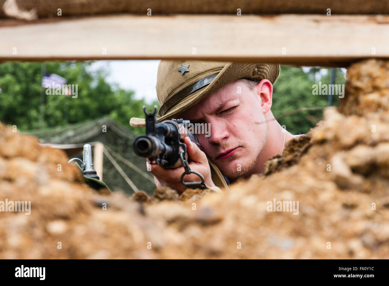 Afghanistan Krieg Re-enactment. Close-up, junge russische Special forces Soldat zielte mit AK 47 Bei der Zuschauer durch das Feuern der Schlitz in der grub-out. Stockfoto