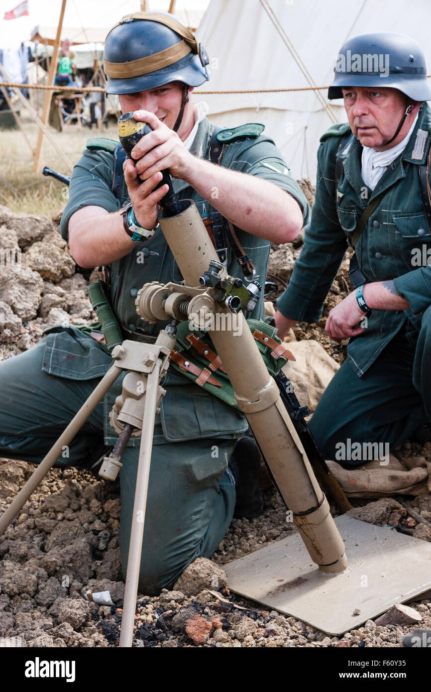 Zweiten Weltkrieg Re-enactment. Zwei Männer, die Mörser Team in kleinen Unterstand. Ein Soldat laden 8 cm-Mörser Shell in Licht Trench mortar. Close Up. Stockfoto