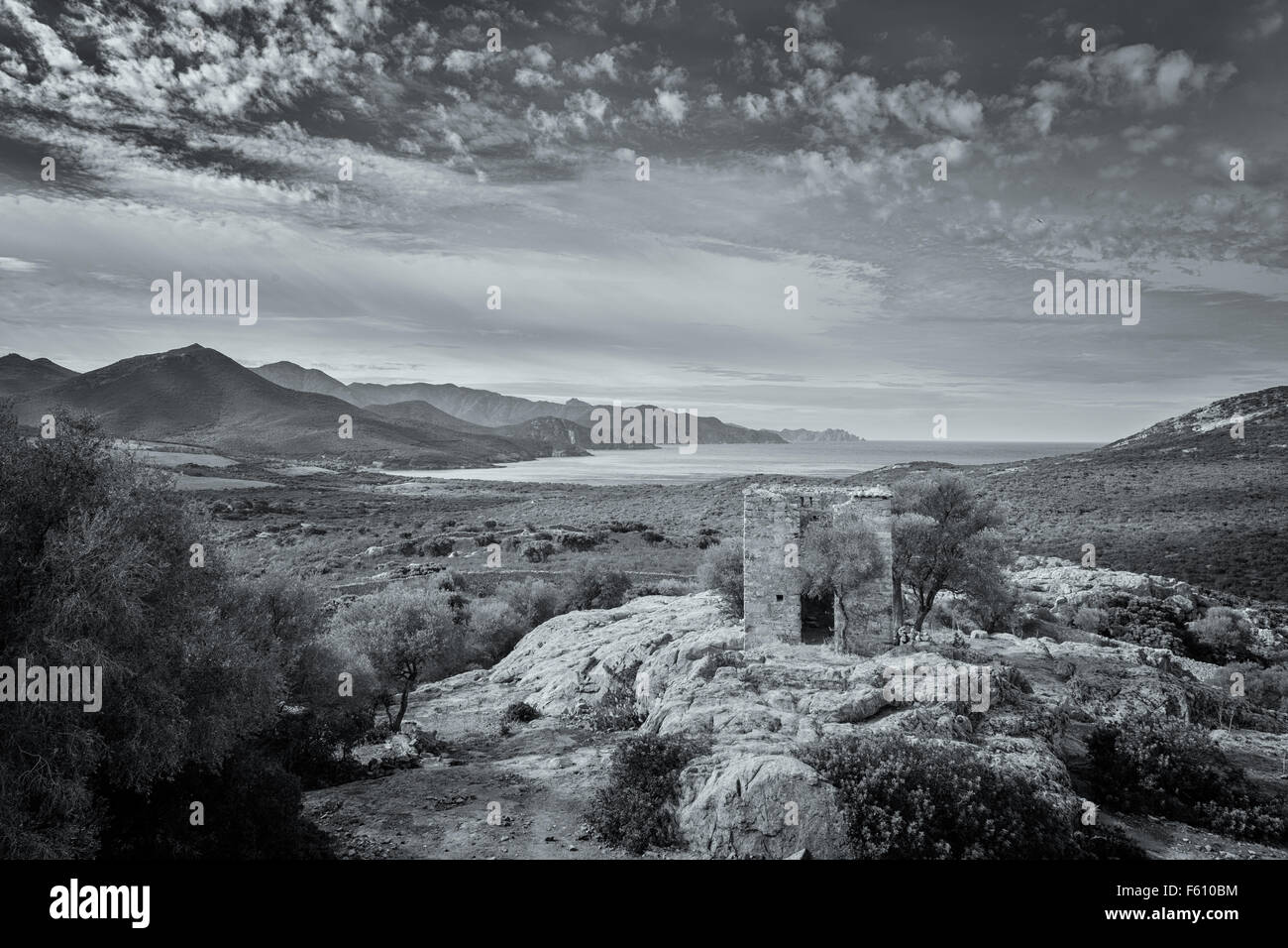 Schwarzen & weißen Blick auf verfallenen Gebäude auf Felsvorsprung und die Küste von Korsika, entnommen aus einem verfallenen Schloss Stockfoto