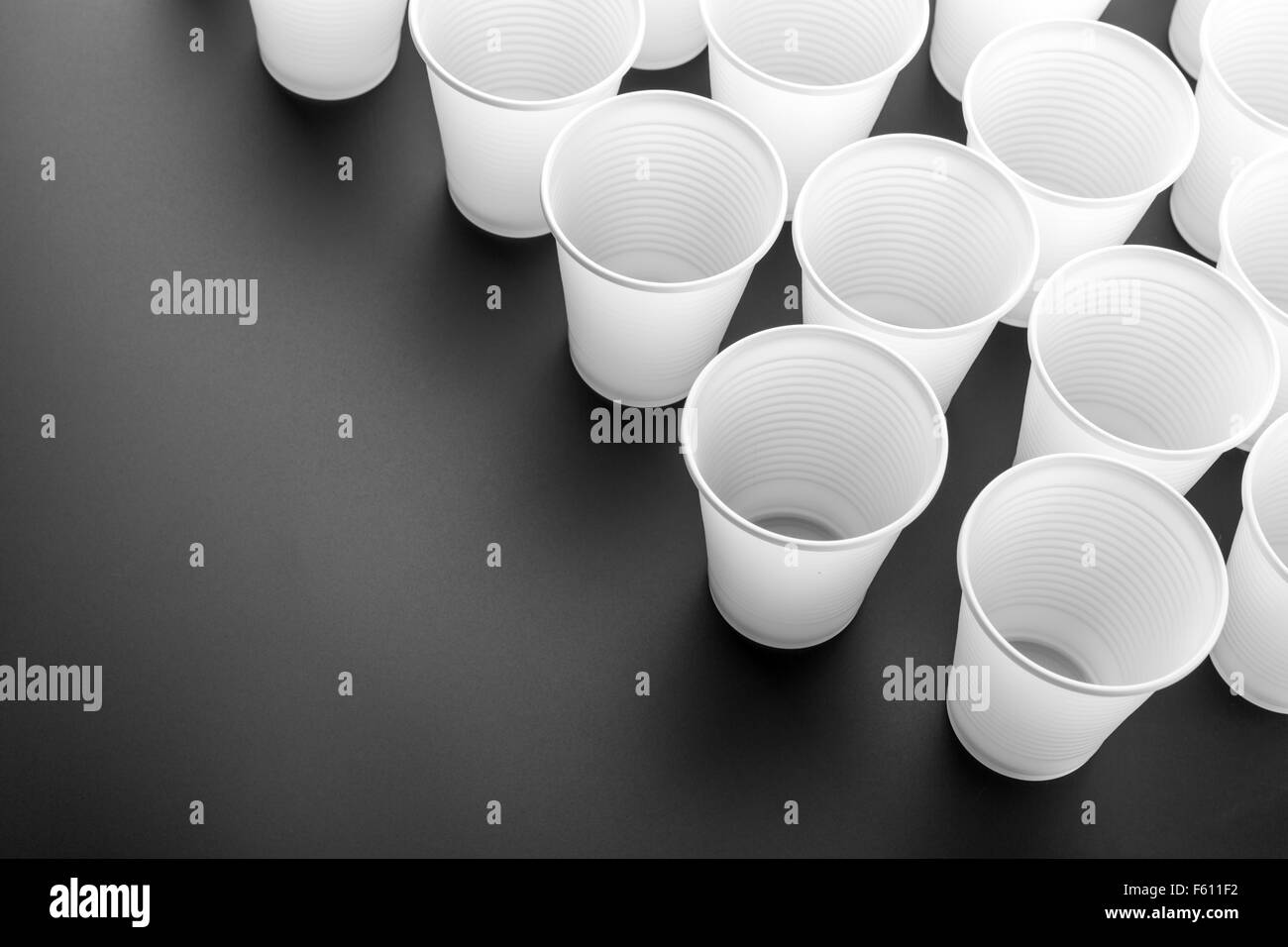 Viele weiße Kunststoff-Gläser auf grauem Hintergrund Stockfoto