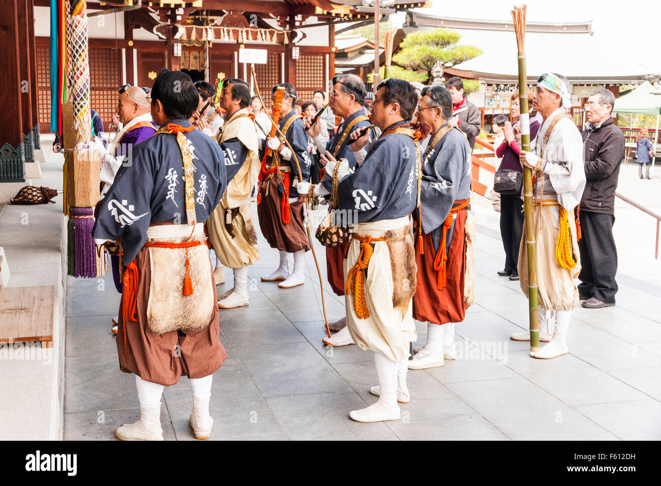 Japan, Nishinomiya, Mondo Yakuji Tempel. Gruppe von Priestern tragen Yamabushi (Krieger, Mönch), Kostüme, beten mit Kopf Priester an Temple Hall. Stockfoto