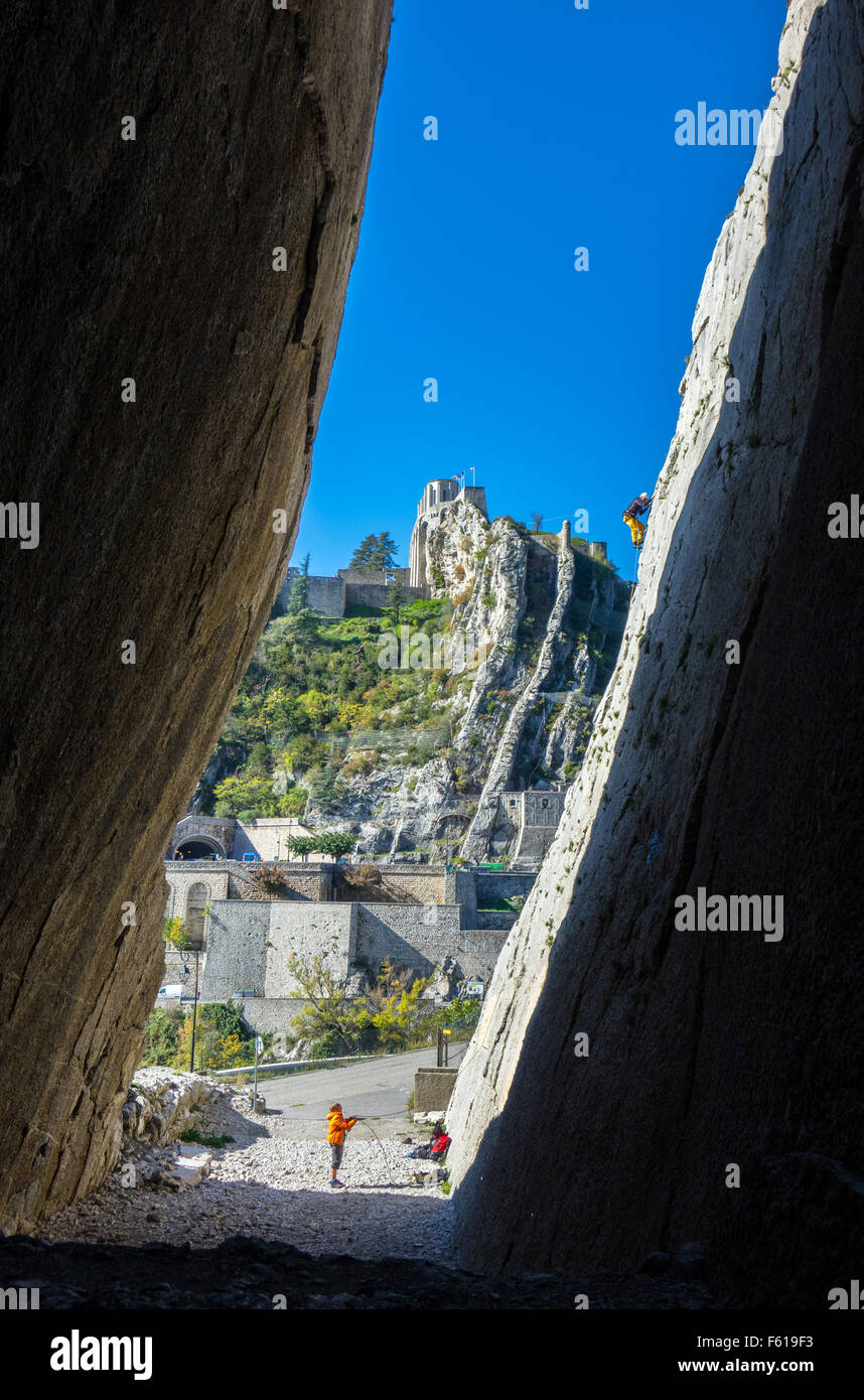 Kletterer in gelben Klettern im Canyon mit Burg über Stockfoto