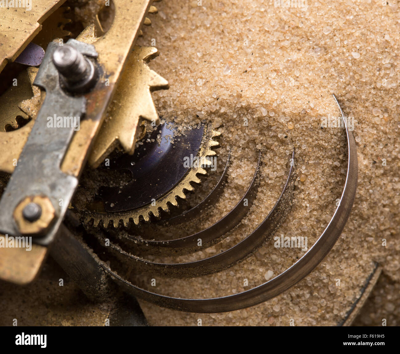 Mechanische Ausdauer - Uhr Zahnräder in sand Stockfoto