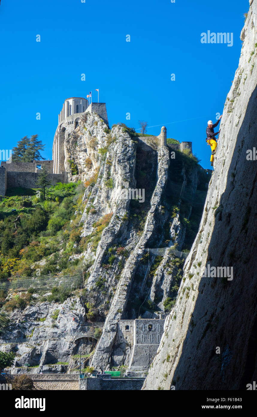 Kletterer in gelben Klettern im Canyon mit Burg über Stockfoto