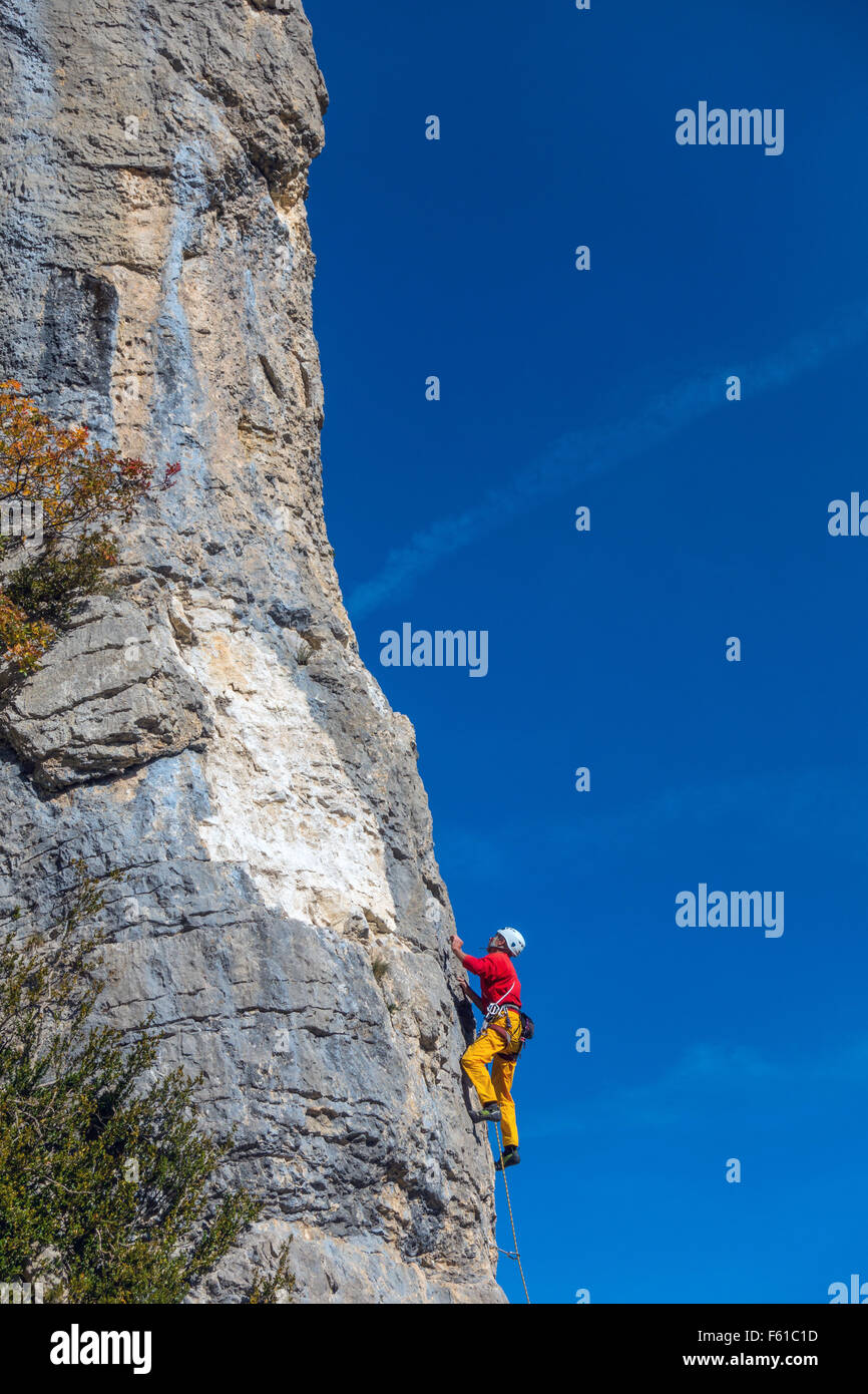 Reife Kletterer in gelb und rot auf Klippe mit blauem Himmel Stockfoto