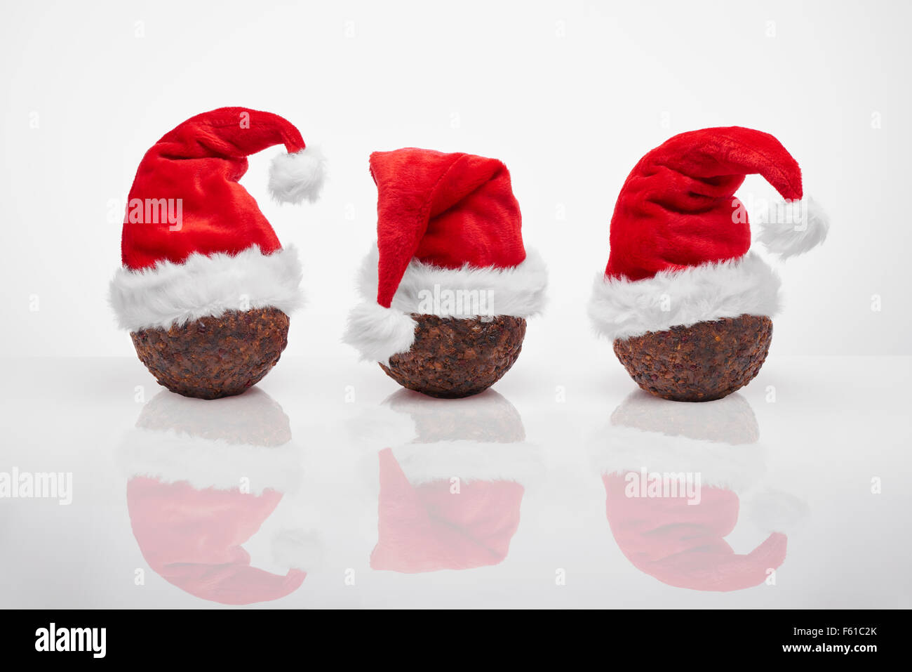 Christmas Pudding mit roten Nikolausmützen Stockfoto