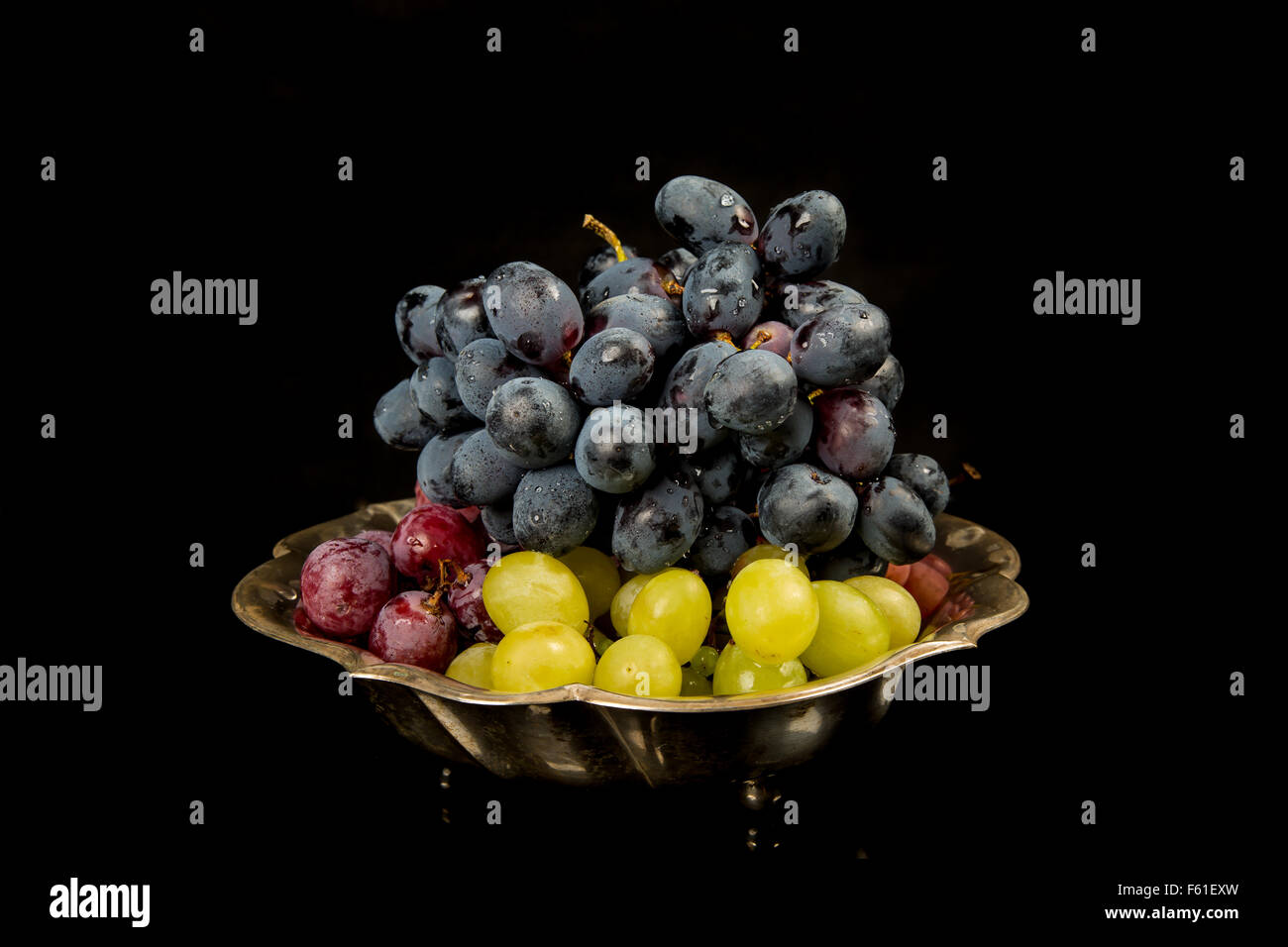 Blaue, rote und gelbe Trauben auf schwarzem Hintergrund Stockfoto