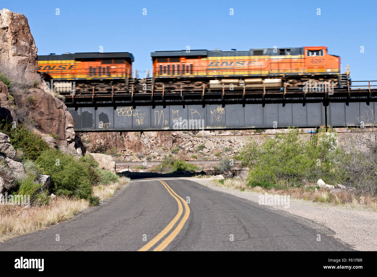 Ein Burlington Northern Güterzug geht über die Nationalstraße alte Pfade und Route 66 westlich von Kingman, Arizona. Stockfoto