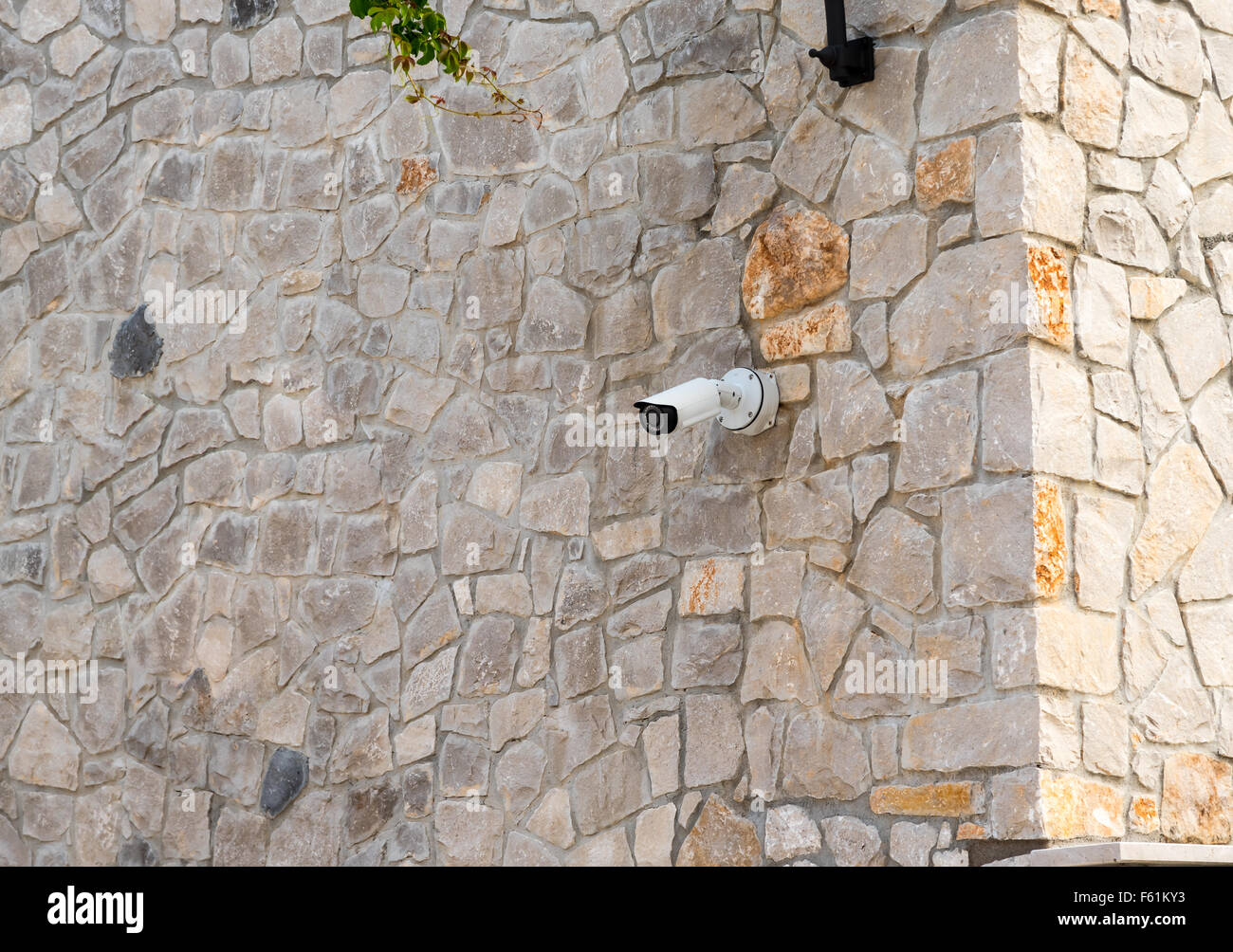 Überwachungskamera auf einer Steinmauer Stockfoto