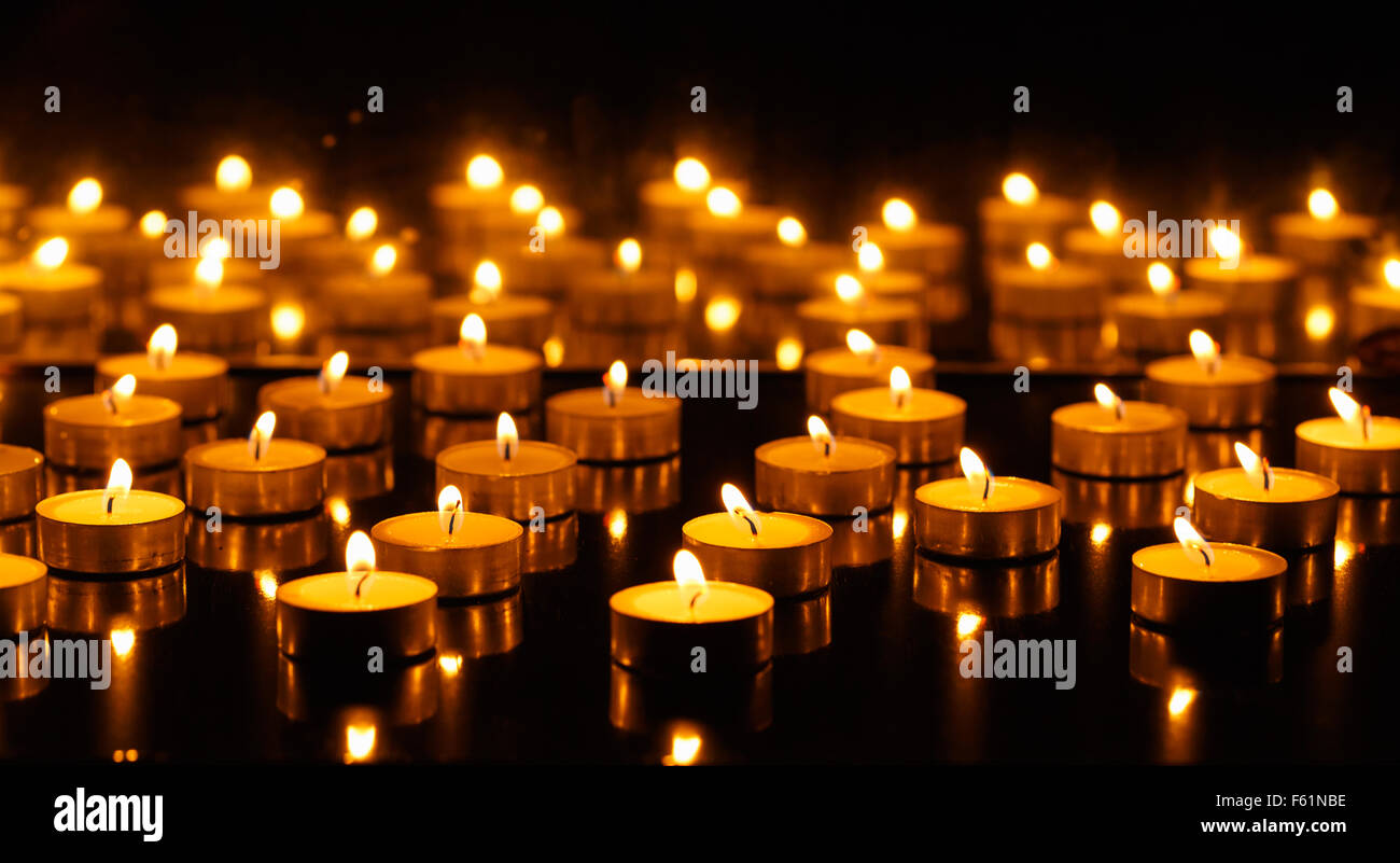 Panorama der vielen brennenden Kerzen mit Bild im Spiegel Stockfoto