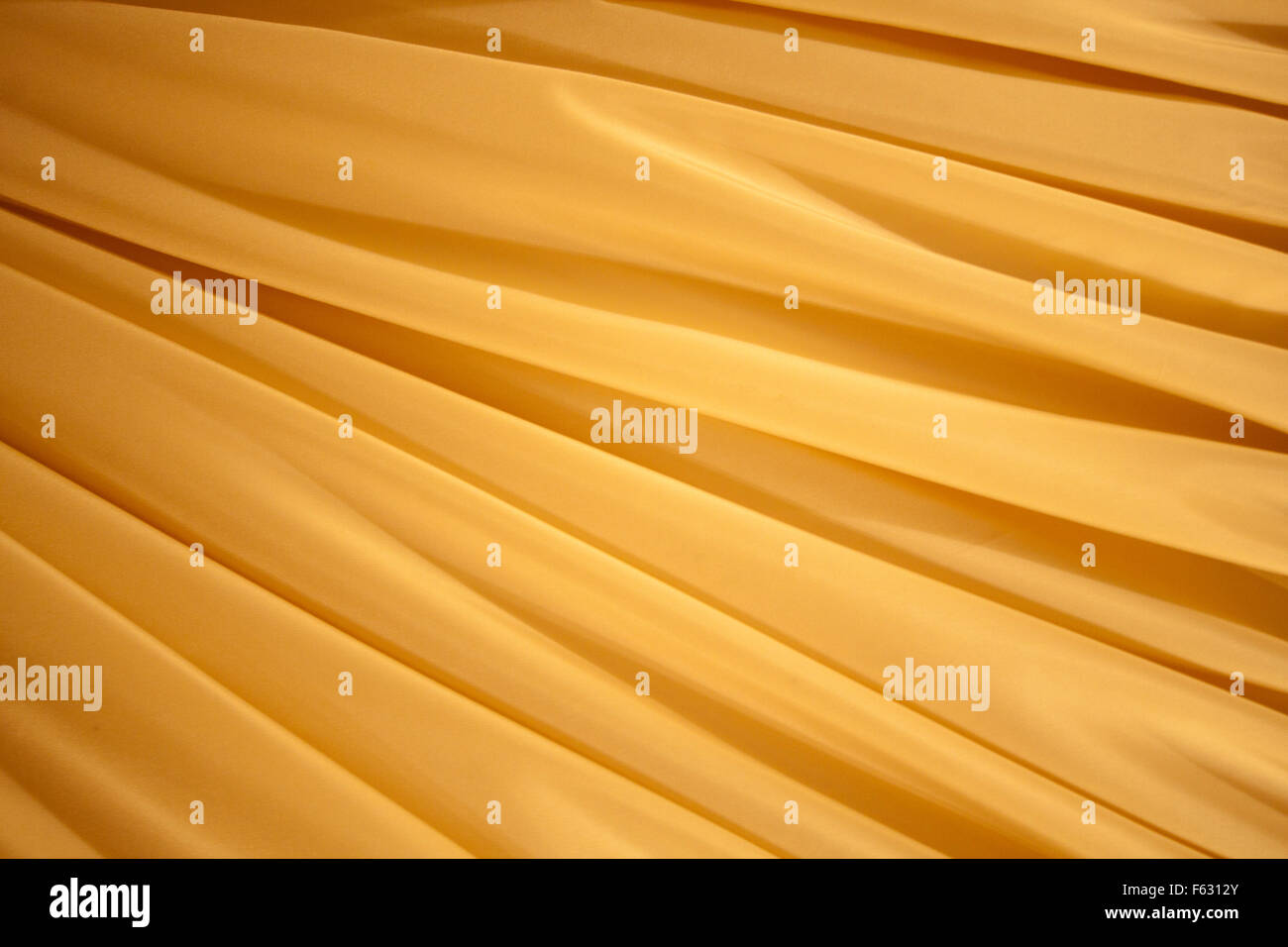 Gelbe Seide Wellen. Hintergrund oder Textur Stockfoto