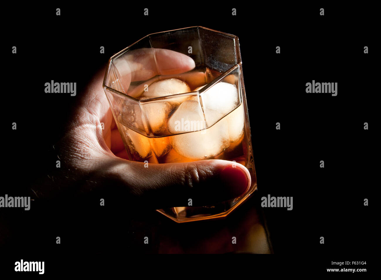 Gold Whisky auf Eis in der Hand des Alkoholikers Stockfoto