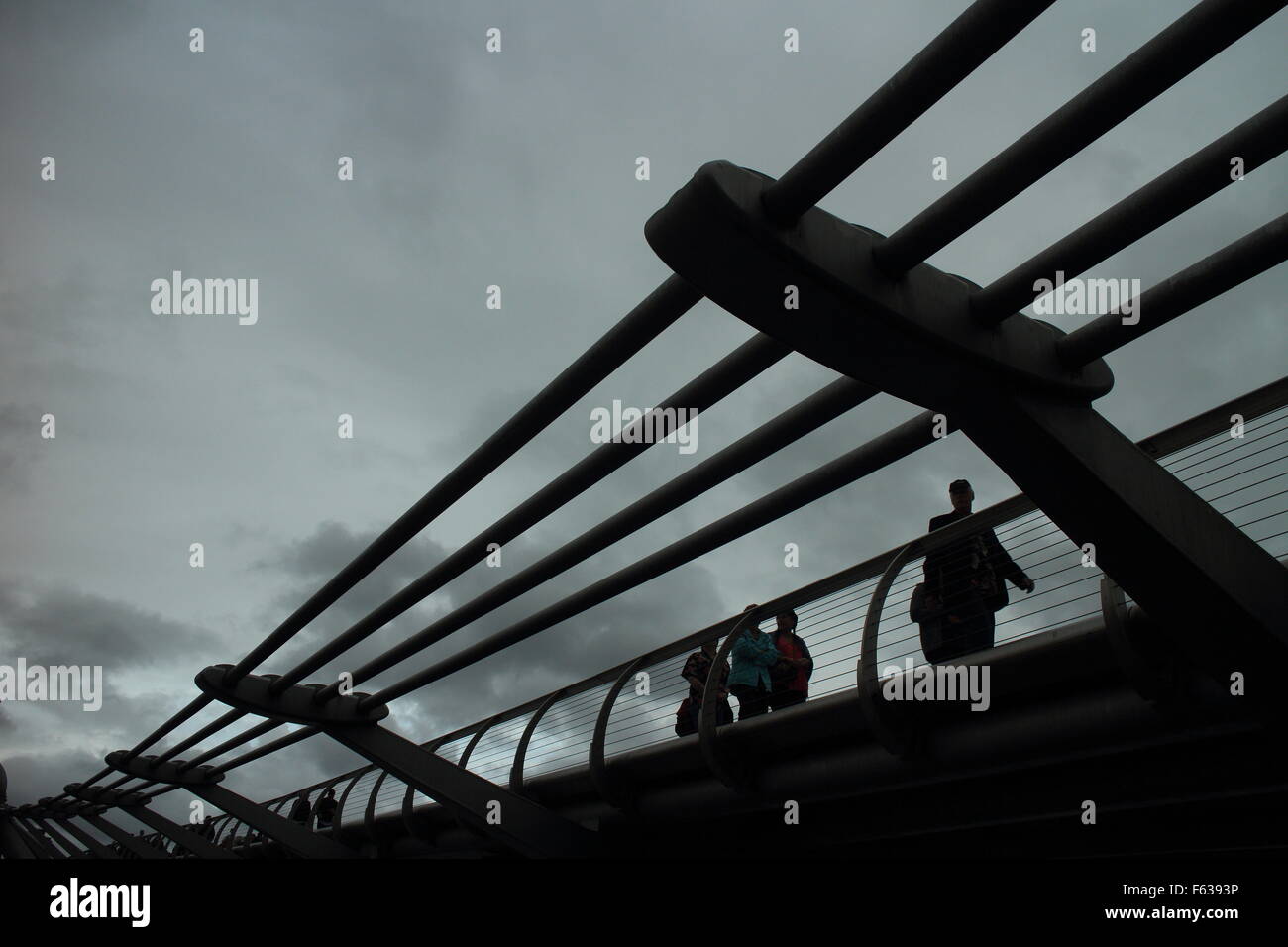 Menschen zu Fuß auf die Millennium Bridge in London an einem regnerischen Tag Stockfoto