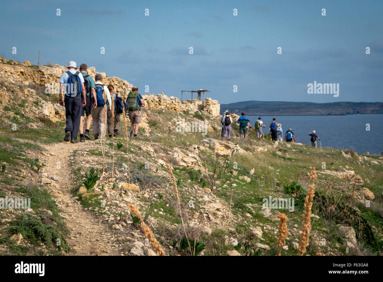 Eine Gruppe von Wanderern vorbei ein Vogel-Jäger verstecken an der Küste von Gozo, Malta. Stockfoto