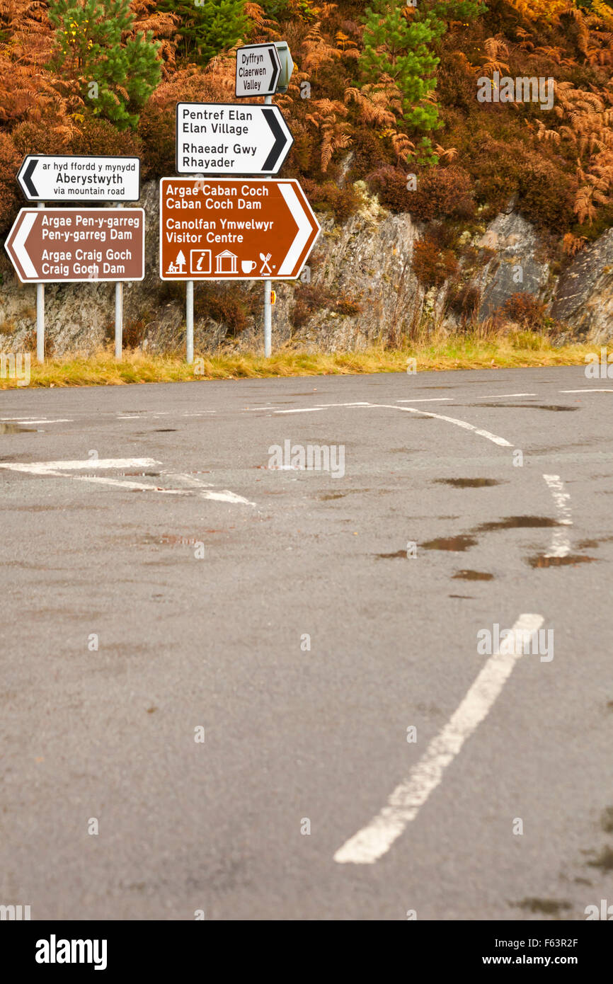 Verkehrsschilder an der Kreuzung am Garreg DDU Dam, Elan Valley, Powys, Mid Wales, Großbritannien im November mit Herbstfarben Stockfoto
