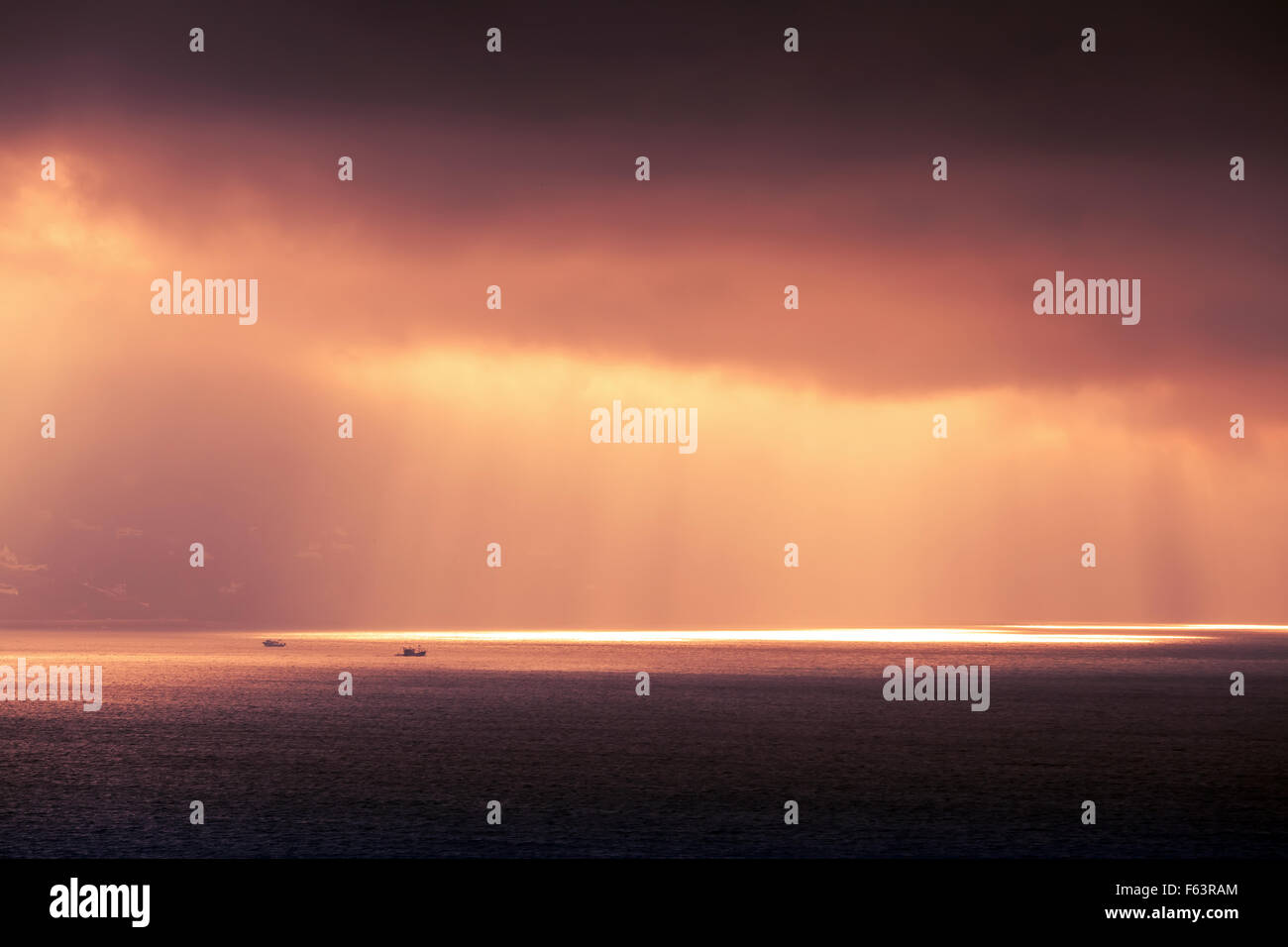 Atlantischen Ozean Landschaft Abend Sonne durchläuft dunkel bewölkter Himmel. Lila rot Tonwertkorrektur-Foto-Filter-Effekt Stockfoto