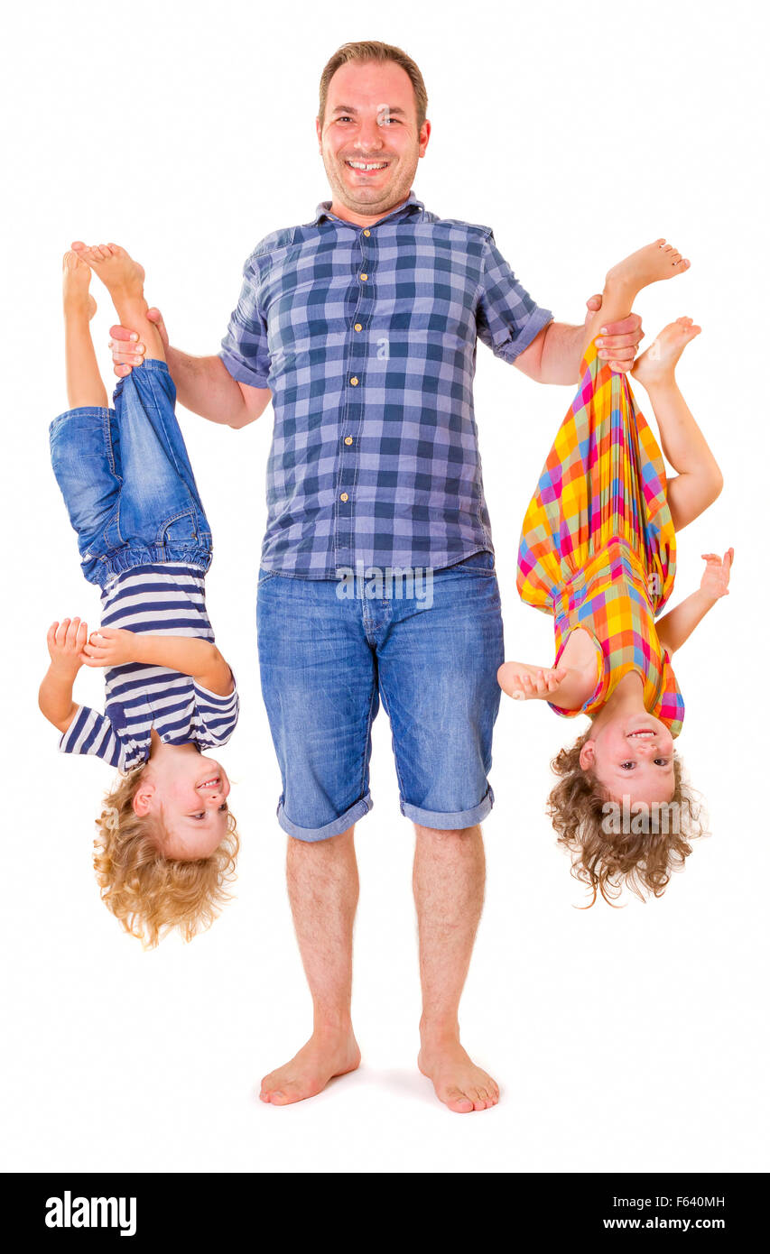 Glücklicher Vater hält seine lächelnden Kinder kopfüber isoliert auf weißem Hintergrund. Stockfoto