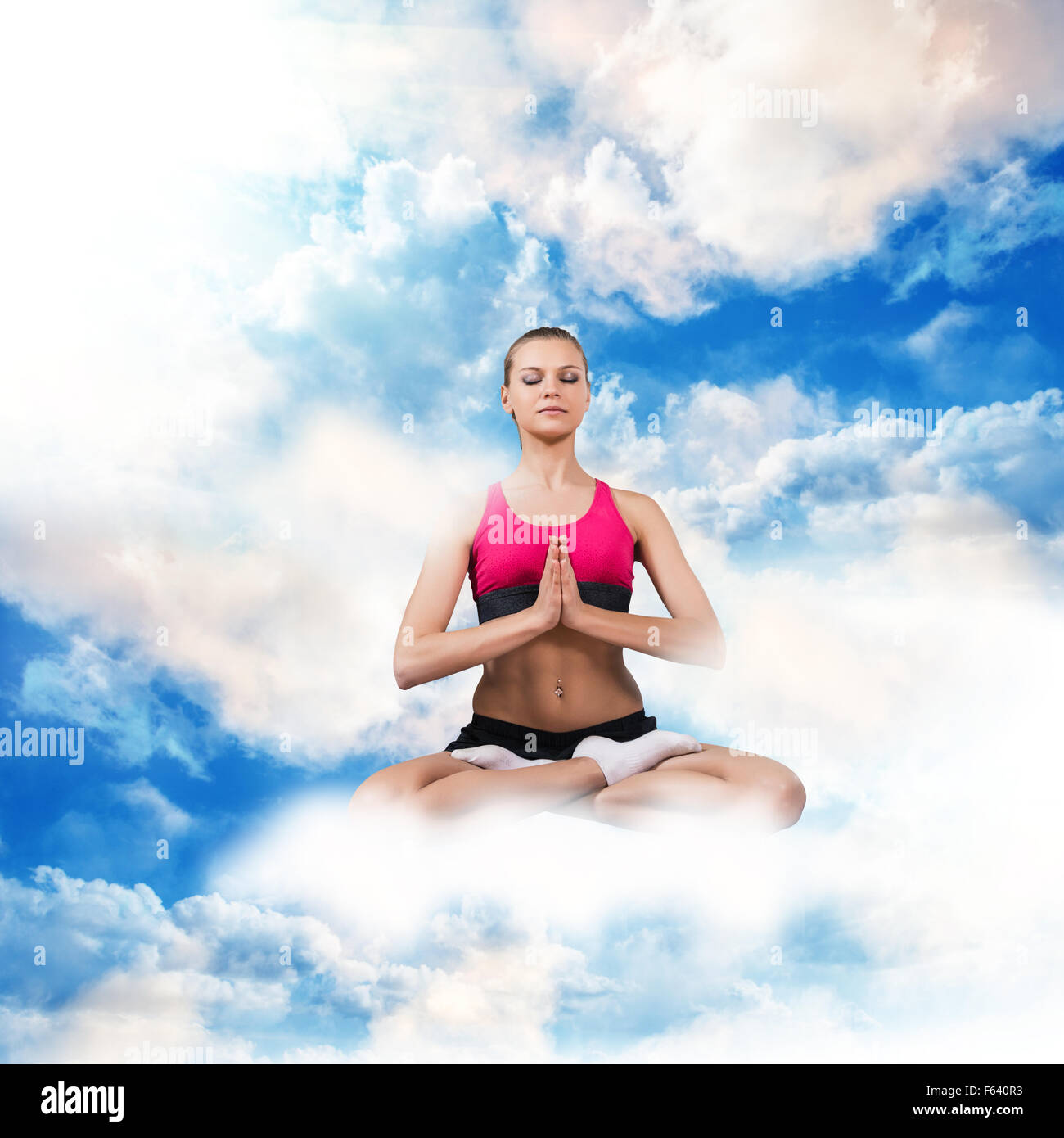 Frau im Lotussitz auf den Wolken Stockfoto