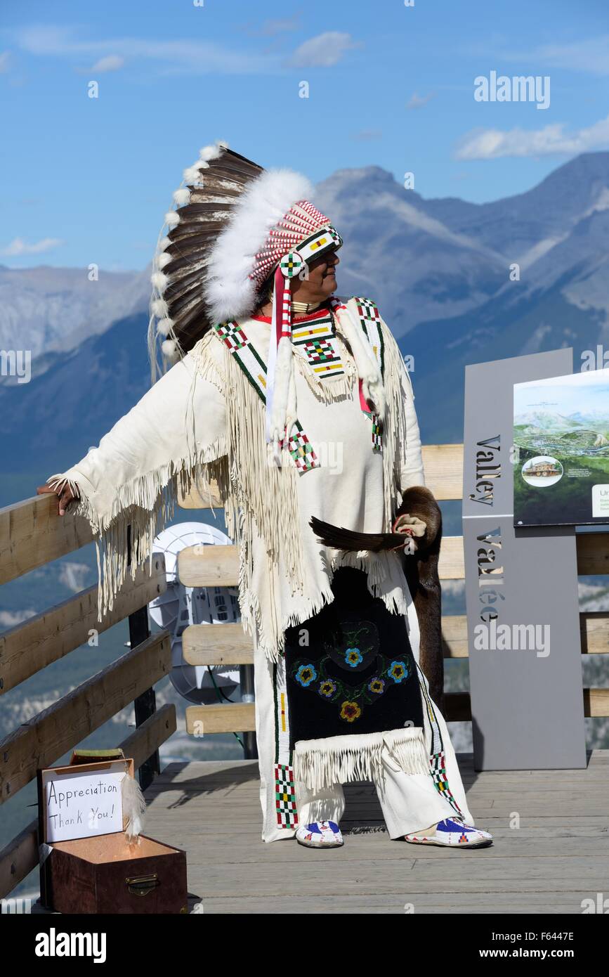 Ein Mann gekleidet in indigene indische zeremonielle Tracht posiert für Fotos auf Sulphur Mountain, Banff, Alberta, Kanada Stockfoto