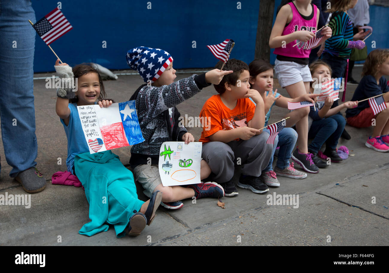 Begeisterten Gruppe von Schulkindern Welle amerikanische Flaggen und jubeln, während ein Veteran-Day-Parade in Austin, Texas Stockfoto