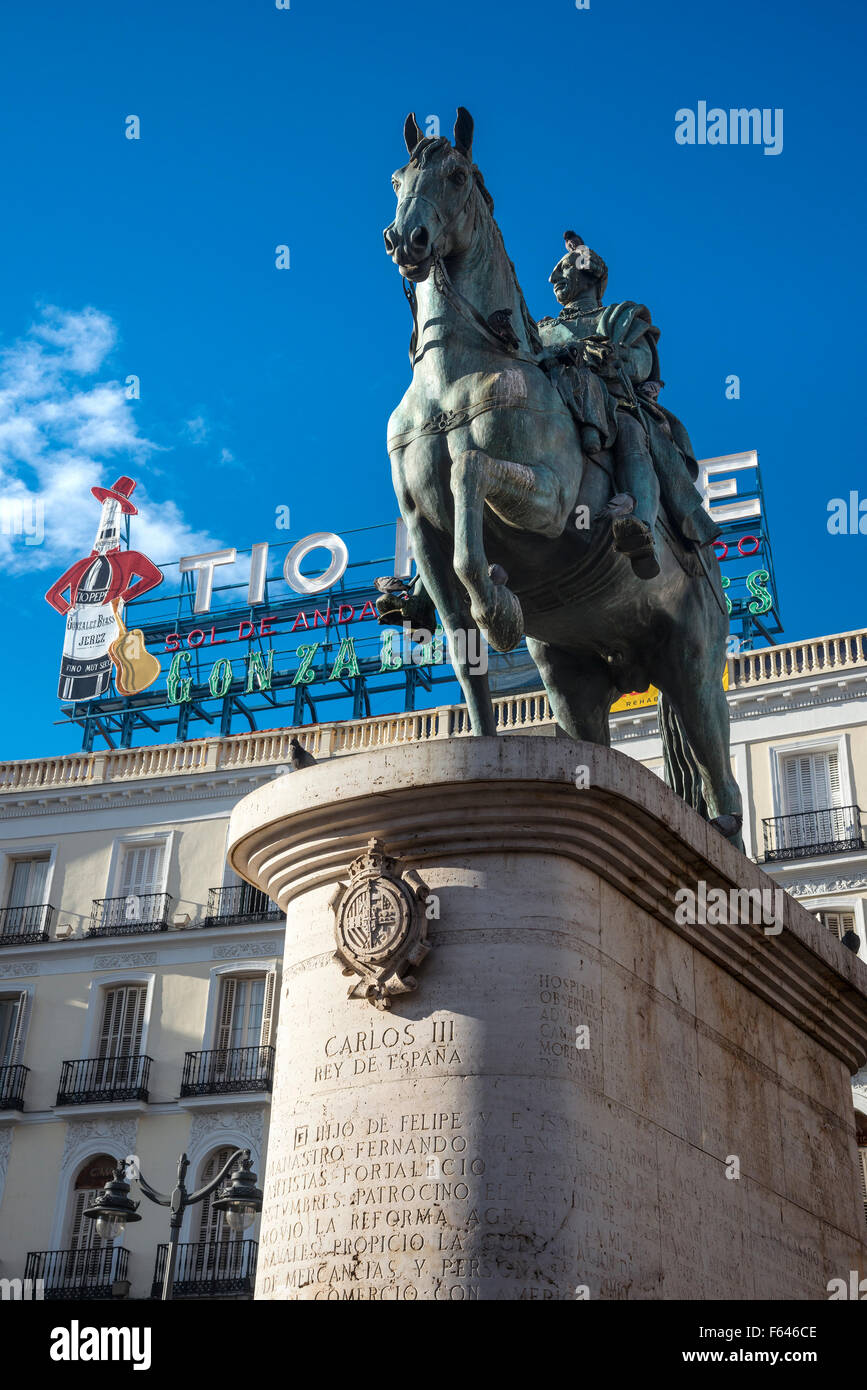 Das berühmte Tio Pepe Reklameschild erhebt sich über eine Statue von König Carlos III, an der Puerta del Sol, Madrid, Spanien. Stockfoto