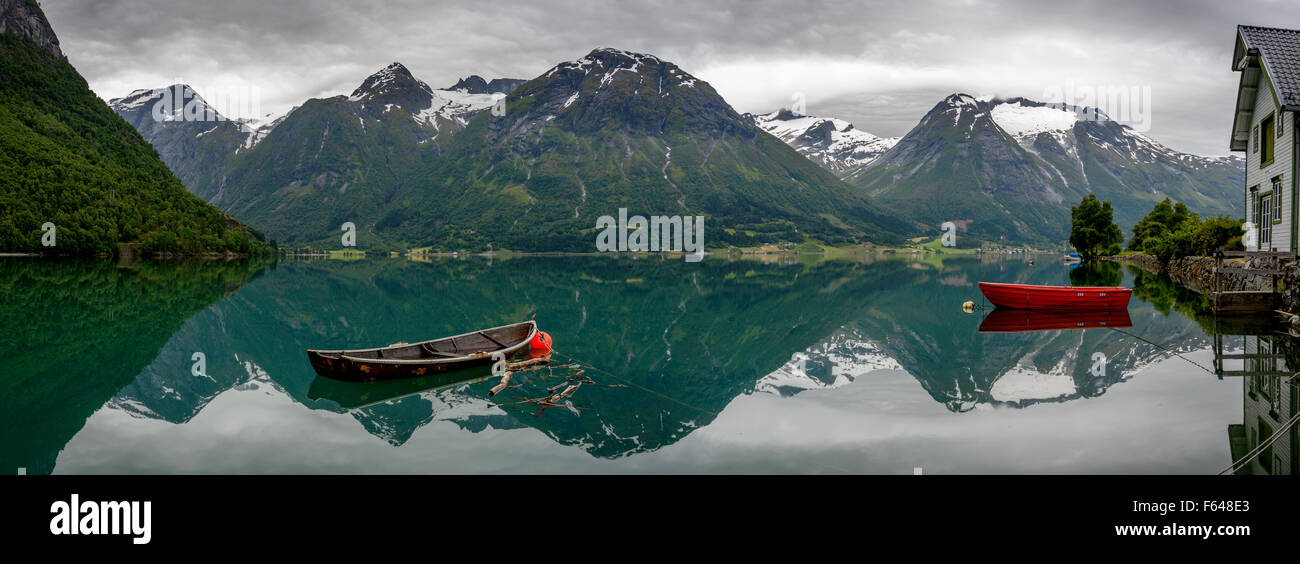Panorama von zwei alten Ruderboote mit Reflexion der Berge in das Stille Wasser des Oppstrynsvatnet-Sees in einer Landschaft von Norwegen. Stockfoto