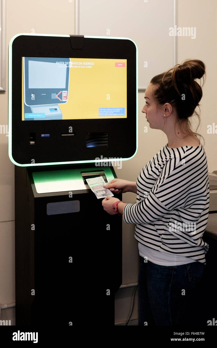 junge Frau mit einem digitalen Währung Bitcoin atm England uk Stockfoto