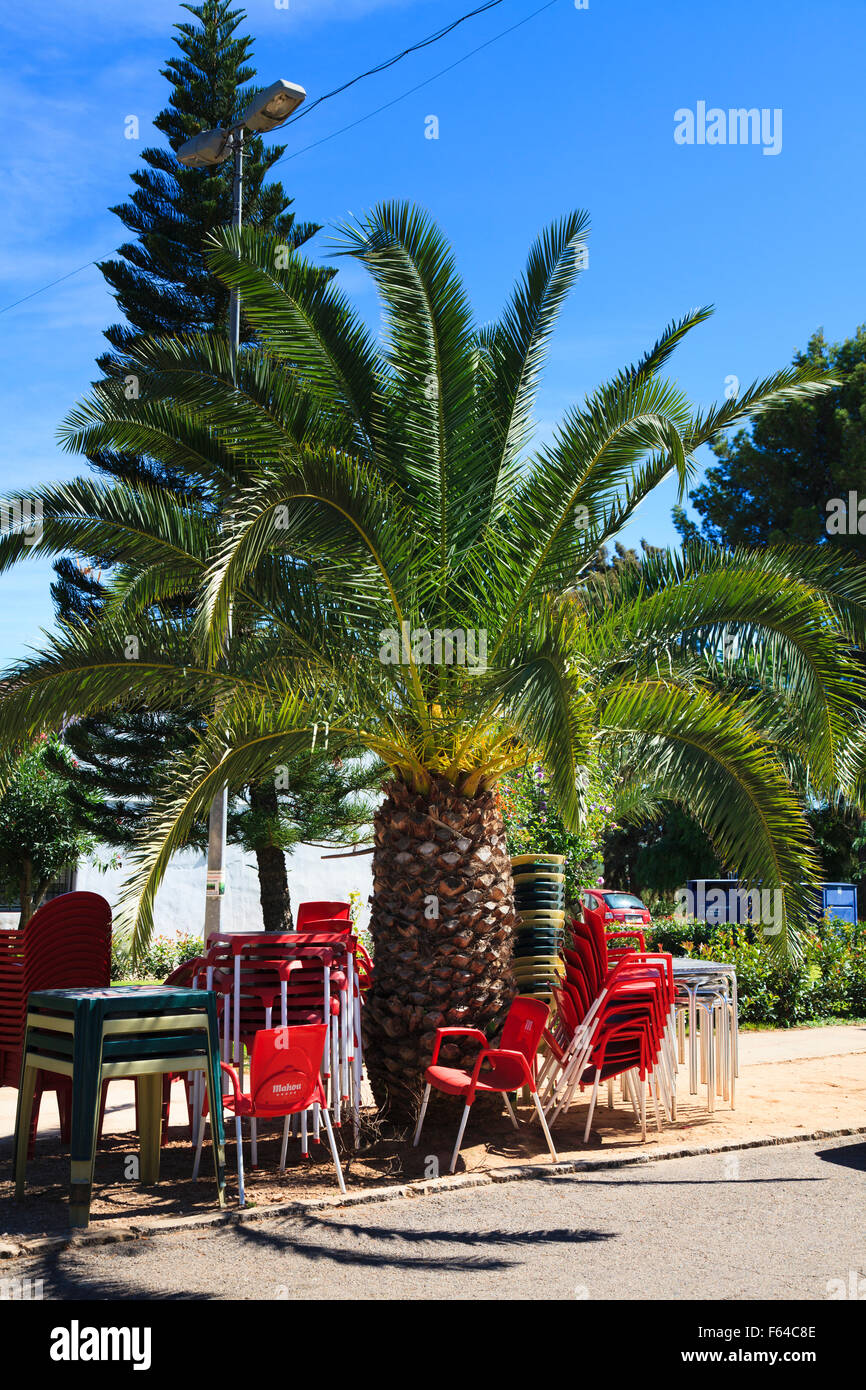 Cafe Stühle gestapelt, unter einer Palme Ananas in Spanien Stockfoto