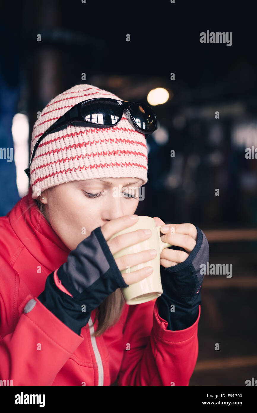 Frau Wanderer trinken heißen Tee oder Kaffee auf Wandertour. Porträt von weiblichen Wanderer in einem Tierheim aus einem Becher trinken und ausruhen Stockfoto