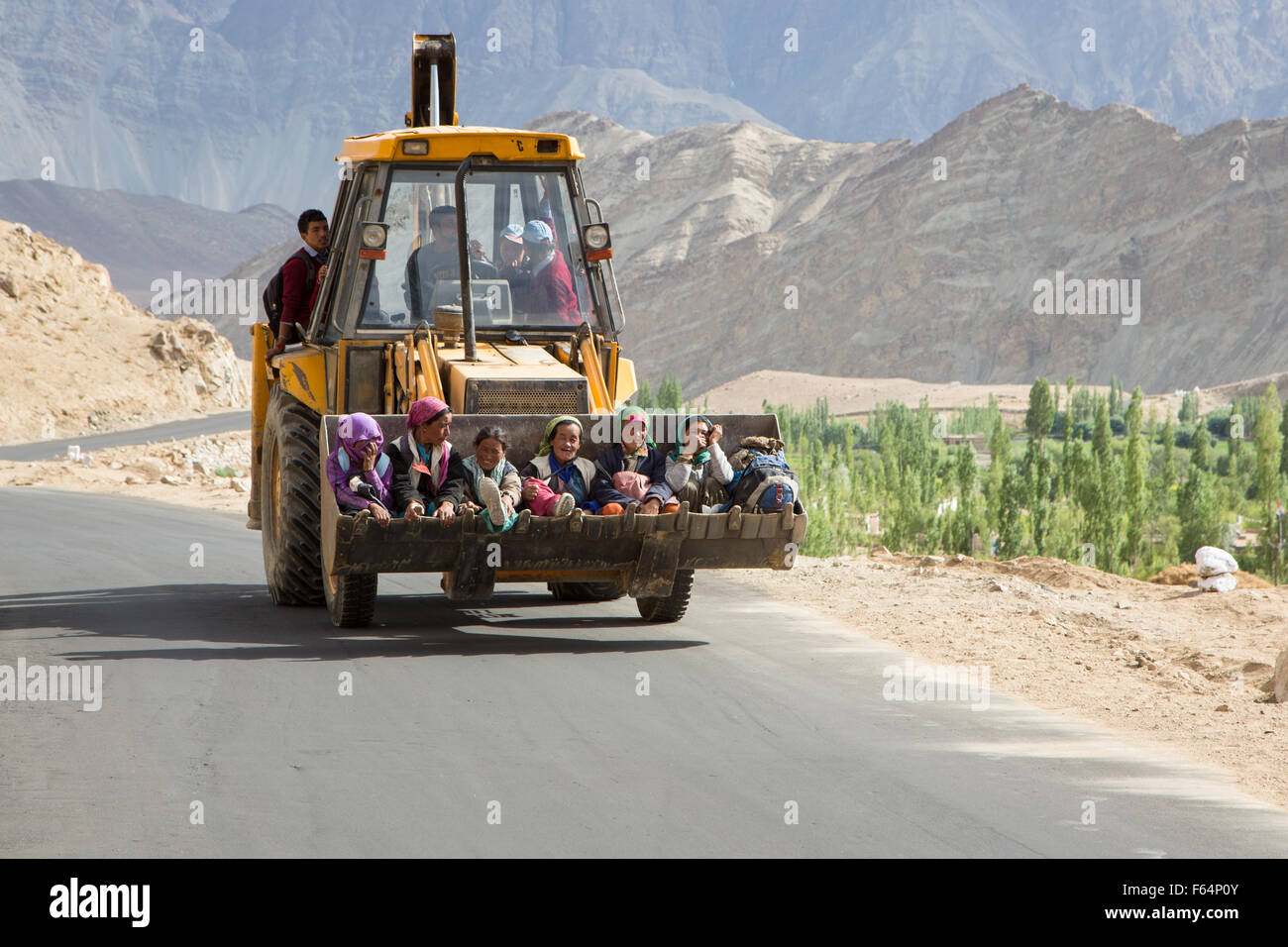 Leh, Indien - 19. Juli 2014: Frauen in Führungspositionen mit einer Erdbewegung Maschine als Transport auf der Straße in Ladakh, Indien Jammu Bestandteil & Stockfoto