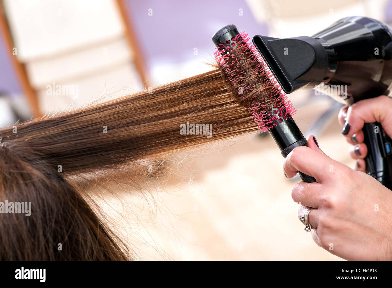Friseur Föhnen lange braune Haare mit einem runden Pinsel, Lift und Volumen  das Haar vorzustellen Stockfotografie - Alamy