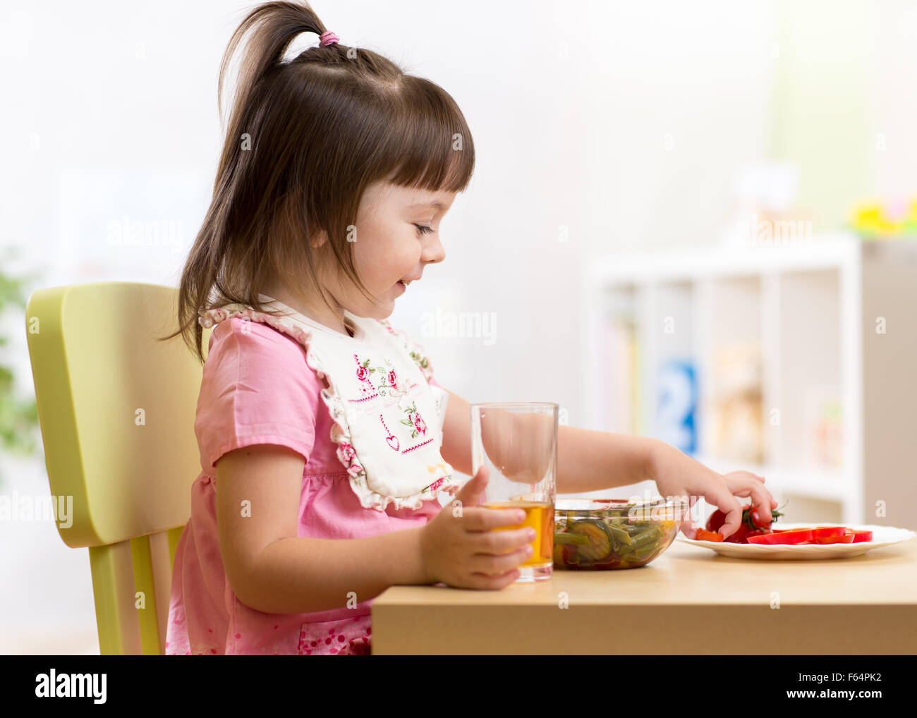 Kind Mädchen essen gesundes Gemüse Stockfoto