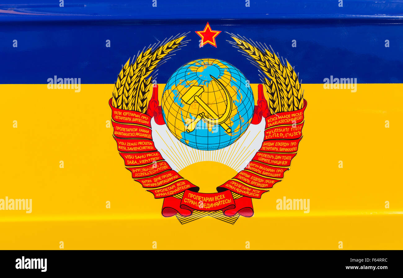 Staatliche Wappen der UdSSR über ukrainische Flagge Stockfoto
