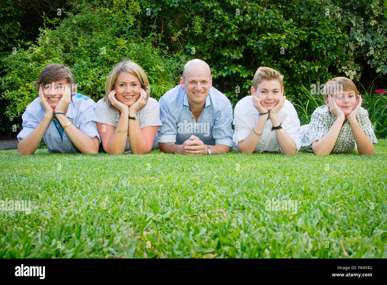 Fünfköpfige Familie posiert auf dem Rasen Stockfoto