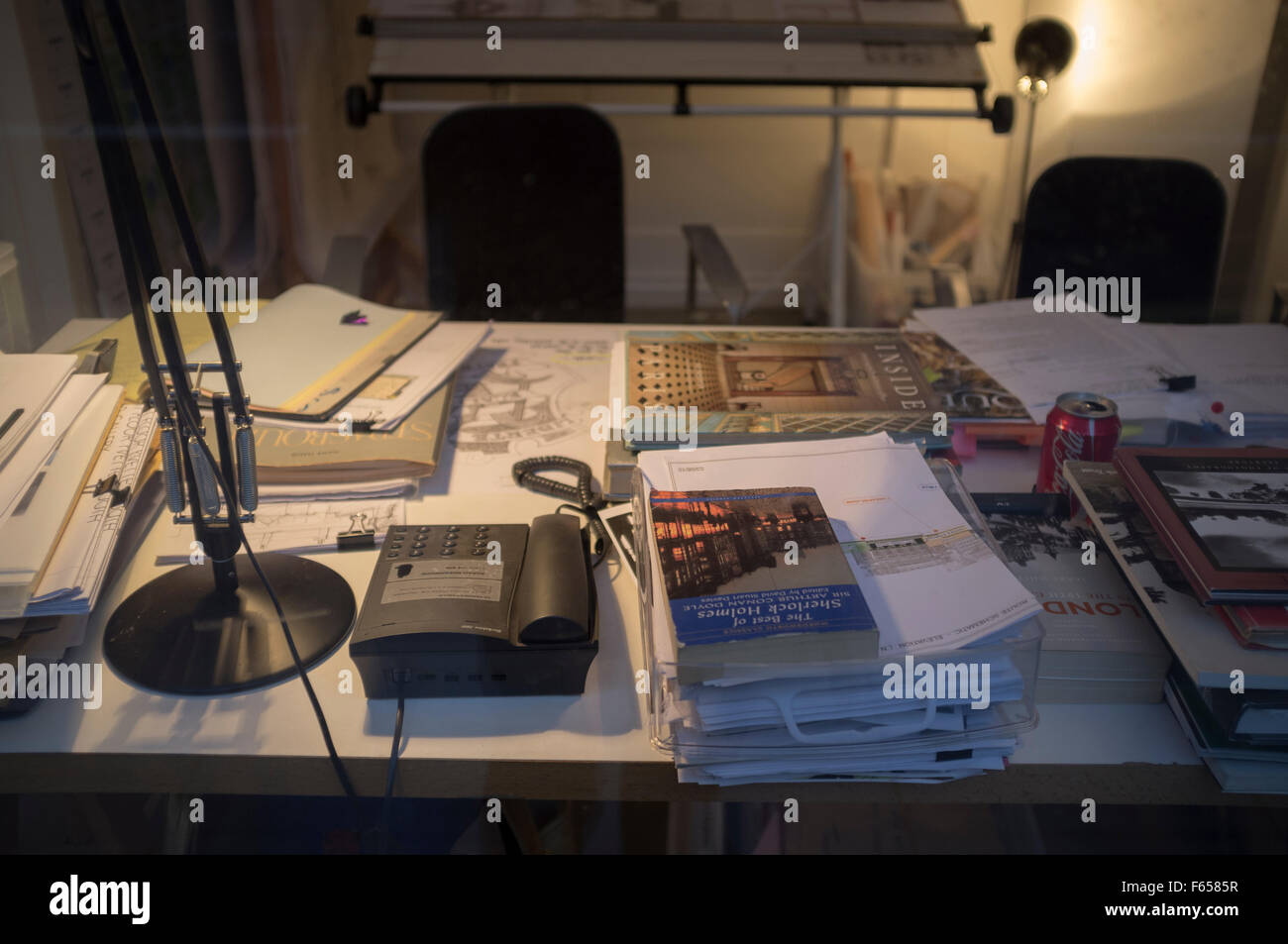Ein überfüllter Schreibtisch von einem Schreibtisch Licht beleuchtet  Stockfotografie - Alamy