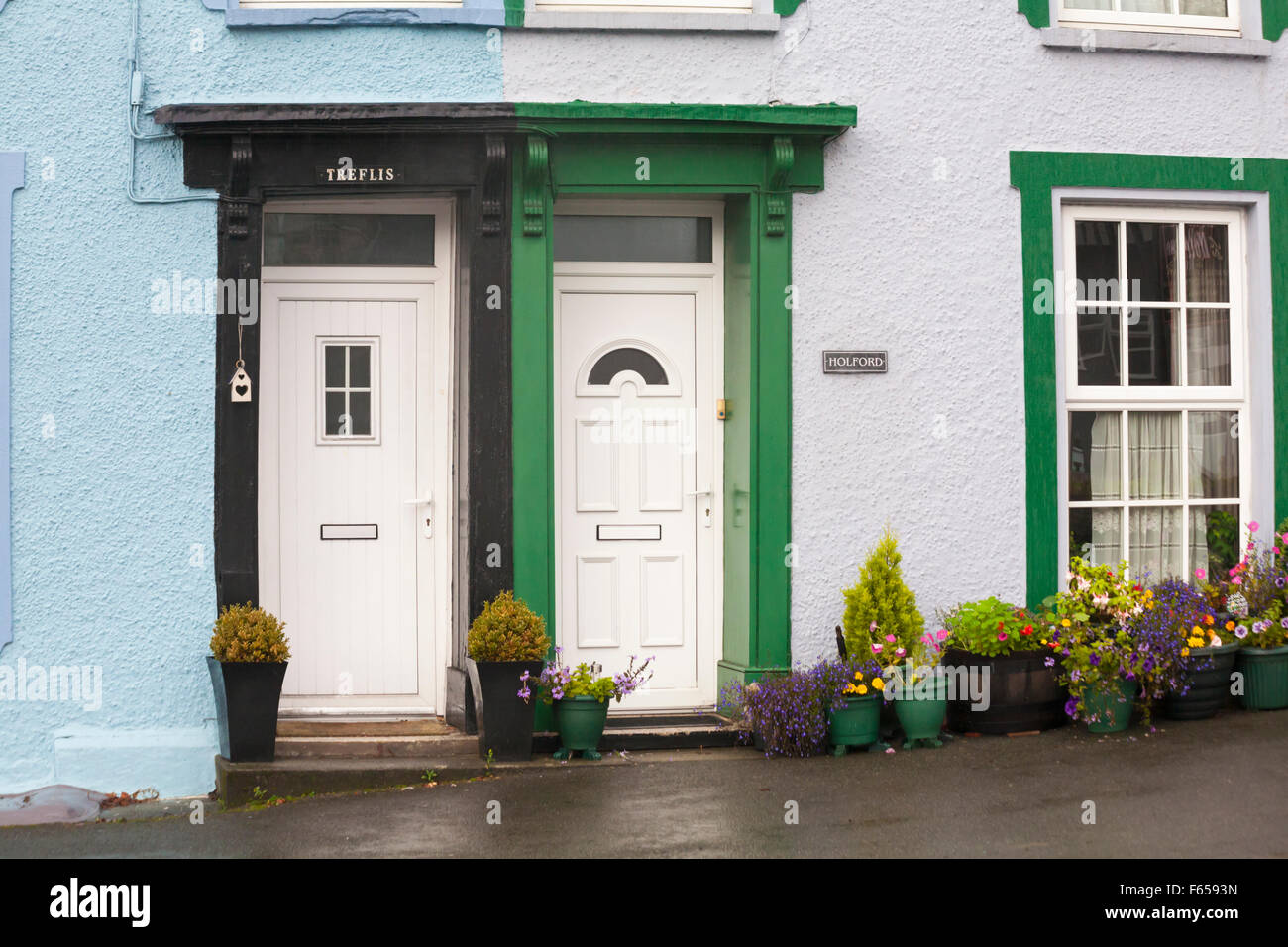 Vordertüren von bunten Häusern Häuser Gebäude in Llanwrtyd Wells, kleinste Stadt in Großbritannien, Powys, Mid Wales, Großbritannien an nassen Regentag im November Stockfoto