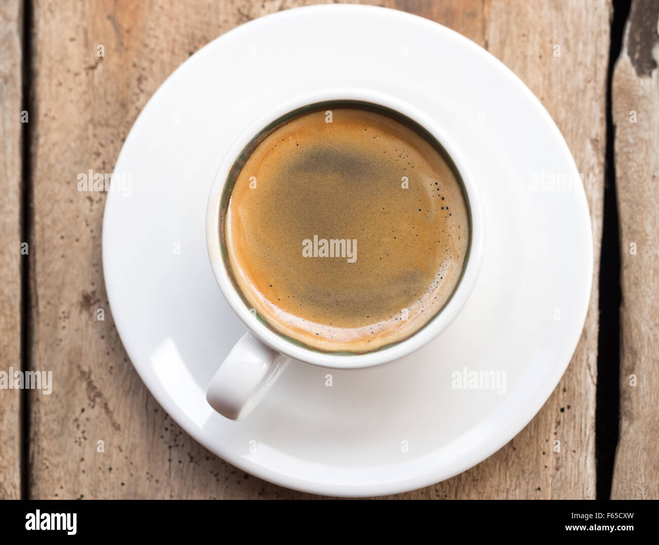 Doppelter Espresso in eine weiße Tasse über einem Dhau Holztisch gelegt. Erhöhten Blick, vertikale Ausrichtung. Erhöhten Blick. Stockfoto
